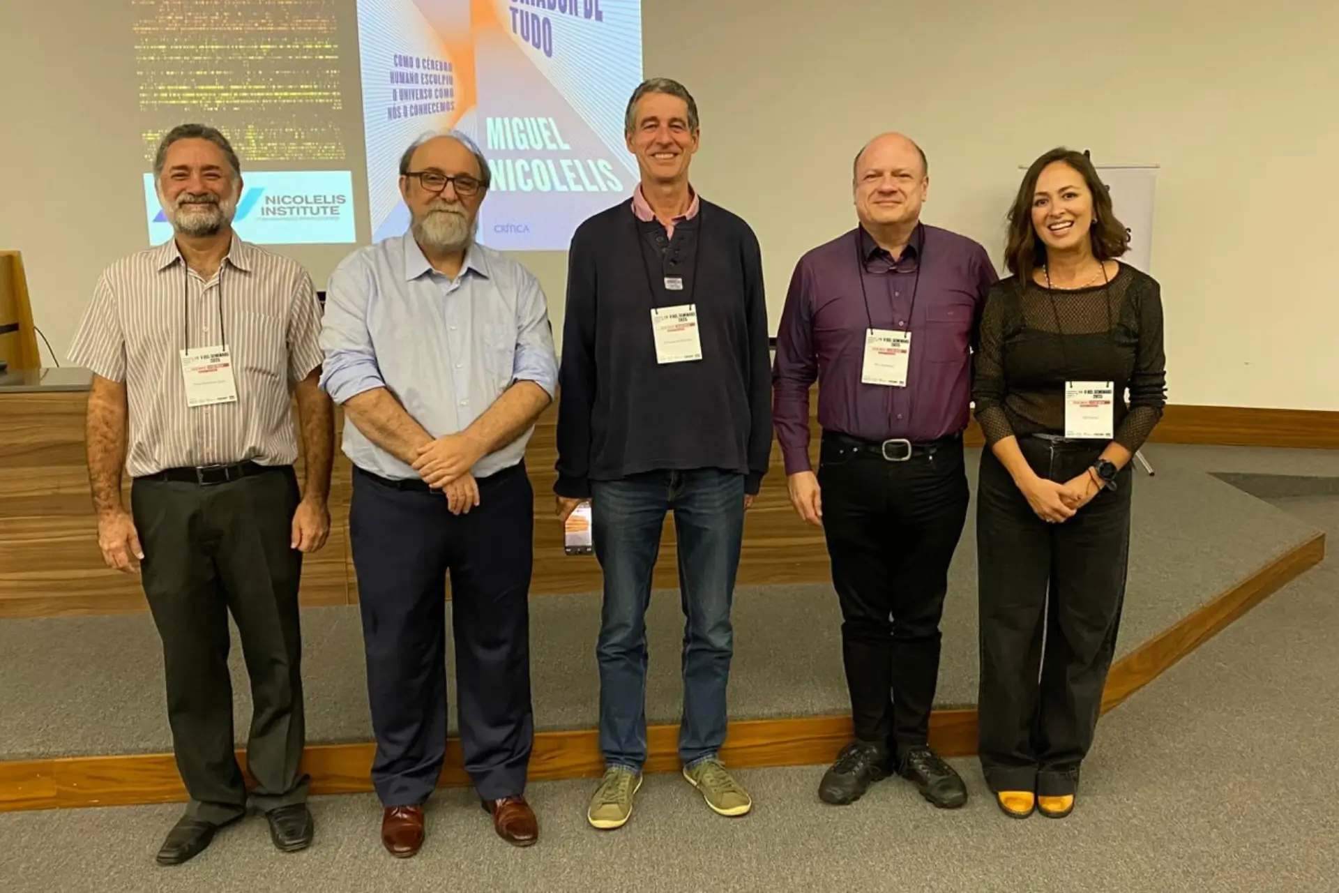 Five BELS participants in front of a presentation in the auditorium